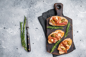 Tapa with Jamon cured ham, parmesan cheese and olives. grey background. top view