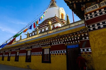 Colorful Dudul Chorten at Kirti Monastery in Ngawa, Amdo (Sichuan), adorned with prayer flags and traditional Tibetan architecture.
