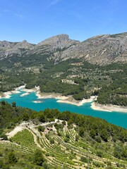 View of the reservoir from the fortress of Guadalest: blue river and mountains under a clear sky on a sunny day. Nature of Spain, province of Alicante.