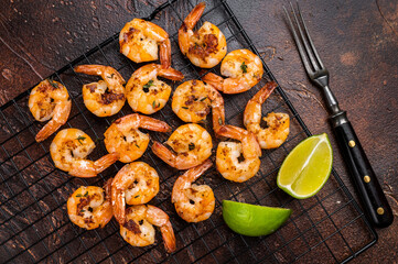 Grilled Shrimps Prawns with garlic on a rack. Brown background. Top view