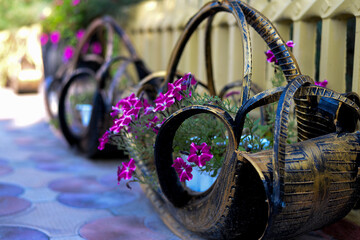 Beautiful flowerbed made of car tires with purple flowers inside
