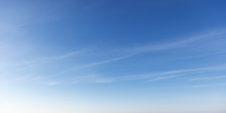 Clear early sky displaying a soothing gradient of blue hues with wispy clouds