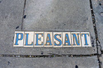 Closeup of Pleasant Street Tile Inlay on Sidewalk in Garden District neighborhood in New Orleans, Louisiana, USA