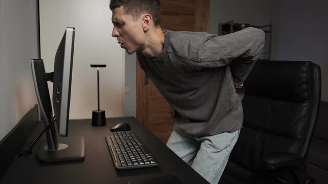 Man experiencing lower back pain office syndrome sedentary lifestyle health risk at home desk authentic home lifestyle