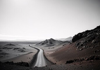 A winding road stretches through a vast, desolate landscape under a pale sky.