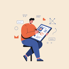 Young man in an orange sweater sitting and drawing on a large digital tablet with a stylus.