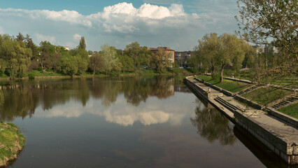 Fototapeta premium Calm River with Trees and Reflections under Blue Sky