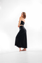 Naklejka premium Model posing in a stylish black outfit on a white background during a studio photoshoot