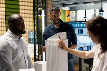 Property contractors team collaborates on residential project strategy, analyzing architectural models to respect zoning regulation analysis for a modern housing construction. Redevelopment.