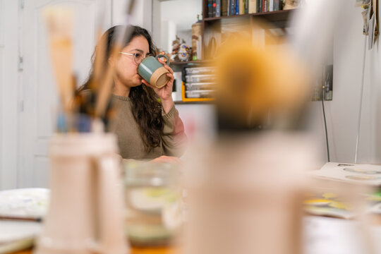 Graphic designer drinking coffee in home studio