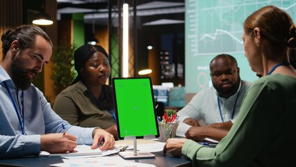 Diverse team in a dark office shares insights and exchanges feedback, finalizing company agenda during a collaborative project briefing with global stakeholders. After hours discussion. Camera A.