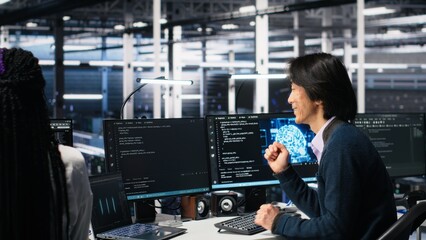 Delighted team in data center celebrating finishing neural network software development. Ecstatic coworkers doing high five in server room after successfully implementing machine learning, camera A