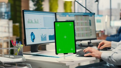 Business consultant examining forecasts with chroma key on tablet, working on extracting...