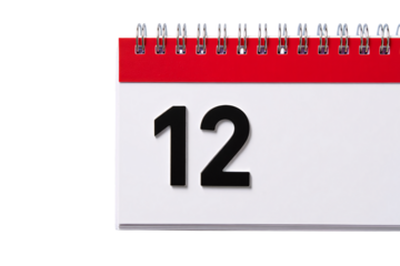 Close up of a spiral bound desk calendar showing the number twelve on a white page isolated on transparent background