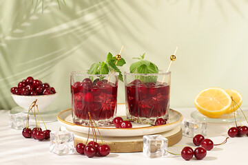 Mojito with cherry, mint, ice with tequila, vodka or soda water on elegant background, minimalist concept for bar, soft and alcoholic drink for weight loss, advertising banner for cafe