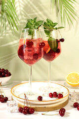 Aperol spritz with cherry, mint, ice with tequila, vodka on elegant background, still life with drinks, minimalist concept for bar, soft and alcoholic drink for weight loss,advertising banner for cafe