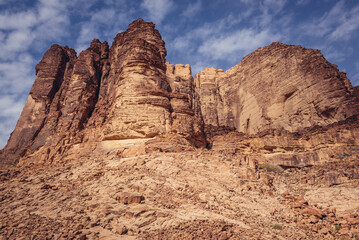 Fototapeta premium Rocky mountain seen from a path to so called Lawrence Spring in famous Wadi Rum - Valley of Sand in southern Jordan