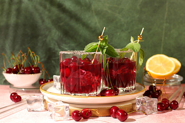 Mojito with cherry, mint, ice with tequila, vodka or soda water on elegant background, minimalist concept for bar, soft and alcoholic drink for weight loss, advertising banner for cafe