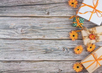 Seasonal autumn presents with ribbons and flowers on wood