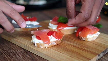 Hands prepare delicious appetizers, arranging slices of smoked salmon, creamy cheese, and red peppers on toasted bread.