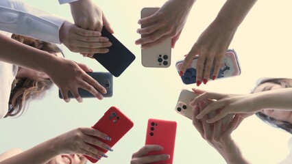 A diverse collection of hands holding various models of smartphones, symbolizing connectivity in technology