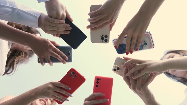 A diverse collection of hands holding various models of smartphones, symbolizing connectivity in technology