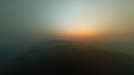 Naklejka premium Serene Landscape with Soft Mist and Vibrant Sunrise over Distant Mountains in Tranquil Atmosphere