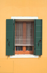 Traditional Venetian window with green shutters