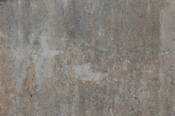Close-up texture of a raw concrete wall. The surface shows natural imperfections, small holes, and subtle variations in color, typical of unfinished or industrial-style concrete.