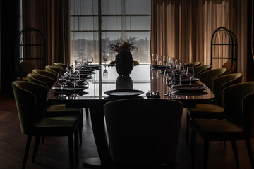 Table before dinner with empty plates and glasses in backlight