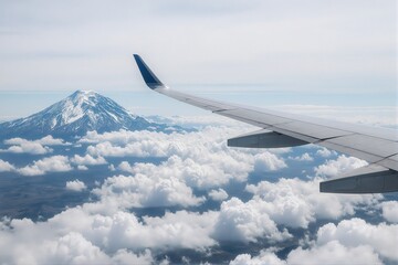Obraz premium Airplane wing flying above clouds with a snow-capped mountain in the background