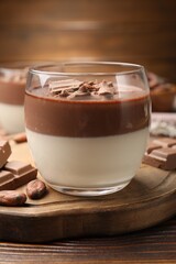 Delicious panna cotta with chocolate and cocoa beans on wooden table, closeup