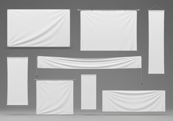 Collection of various blank white advertising banners and signage hanging on poles and ropes against a plain background