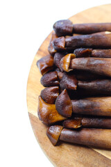 Termite mushrooms with long stems, white tips, and dark brown caps.