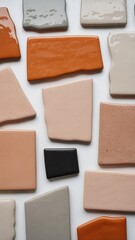 Fototapeta premium A collection of colorful ceramic tiles arranged on a white surface, creating a textured and patterned background isolated on white background
