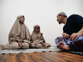 Asian muslim father talking to his daughters after salah pray, communication discussion giving advice