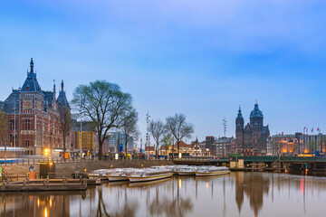 Fototapeta premium Amsterdam Netherlands, night city skyline at Amsterdam Central Station and Basilica of Saint Nicholas