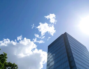 Low-angle view of a modern glass skyscraper against a bright blue sky with fluffy clouds