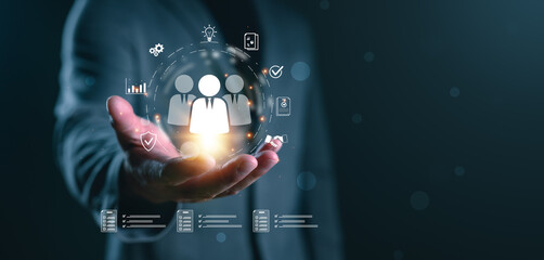 Human resource and team management concept with businessman holding digital team icon, representing employee data system, workforce management, business connection, leadership and talent analytics.