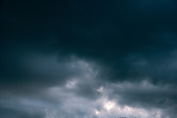 Fototapeta premium Dramatic dark storm rain clouds black sky background. Dark thunderstorm clouds rainny atmosphere. Meteorology danger windstorm disasters climate. Dark cloudscape storm disaster gloomy gray cloud sky