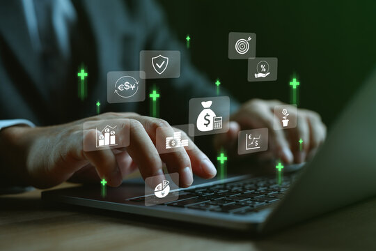 Hands typing on laptop with financial icons, showing investment growth, currency exchange, fintech technology, savings management, interest rate and secure digital banking strategy concept.