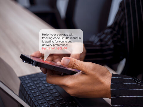 Business person hold phone, receiving scam SMS attack with fake delivery tracking link, illustrating concept of SMS phishing, online fraud, cybercrime, and cybersecurity threat targeting mobile users.