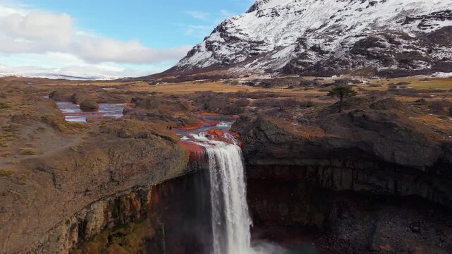 Aerial view of El Salto del Agrio waterfall in Caviahue, Neuqu&eacute;n, Argentina, with snowy andean mountains in background