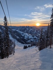 Obraz premium Beautiful Sunset Over Snowy Mountains With Ski Lift in the Foreground During Evening Hours in Winter Season