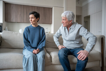 Angry elderly husband berating wife with gaslighting behavior, woman in fear on sofa. Narcissistic...