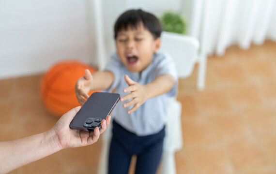 Child reaching for smartphone from parent, screen time control, tech addiction in kids, digital parenting mobile gaming habits, cartoon watching, modern family, children addicted to mobile phones - Powered by Adobe