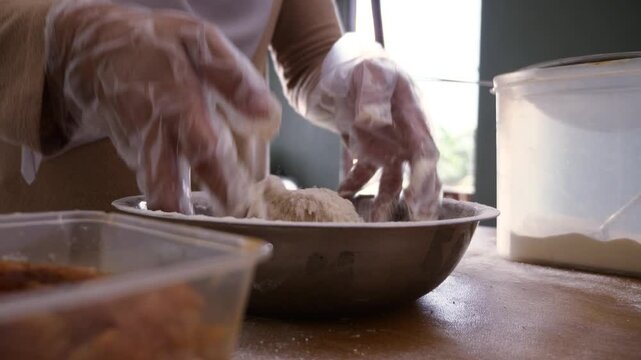 Asian muslim woman breading chicken, coatingmeat with flour before frying