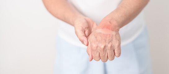 Fototapeta premium Elderly Woman having wrist pain with Medicated pain relief patch plaster for Carpal Tunnel Syndrome, Wrist Tendinitis, muscle ache, De Quervain s tenosynovitis, Hand Osteoarthritis and Senior health