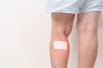Elderly woman having Calf pain with Medicated pain relief patch plaster for concepts of Calf Muscle Strain, muscle pull, Leg Cramp, Sprain, aches, Varicose Veins, Deep Vein and world Thrombosis day