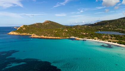 Obraz premium A breathtaking vista of a secluded beach, turquoise waters, and lush green hillsides.